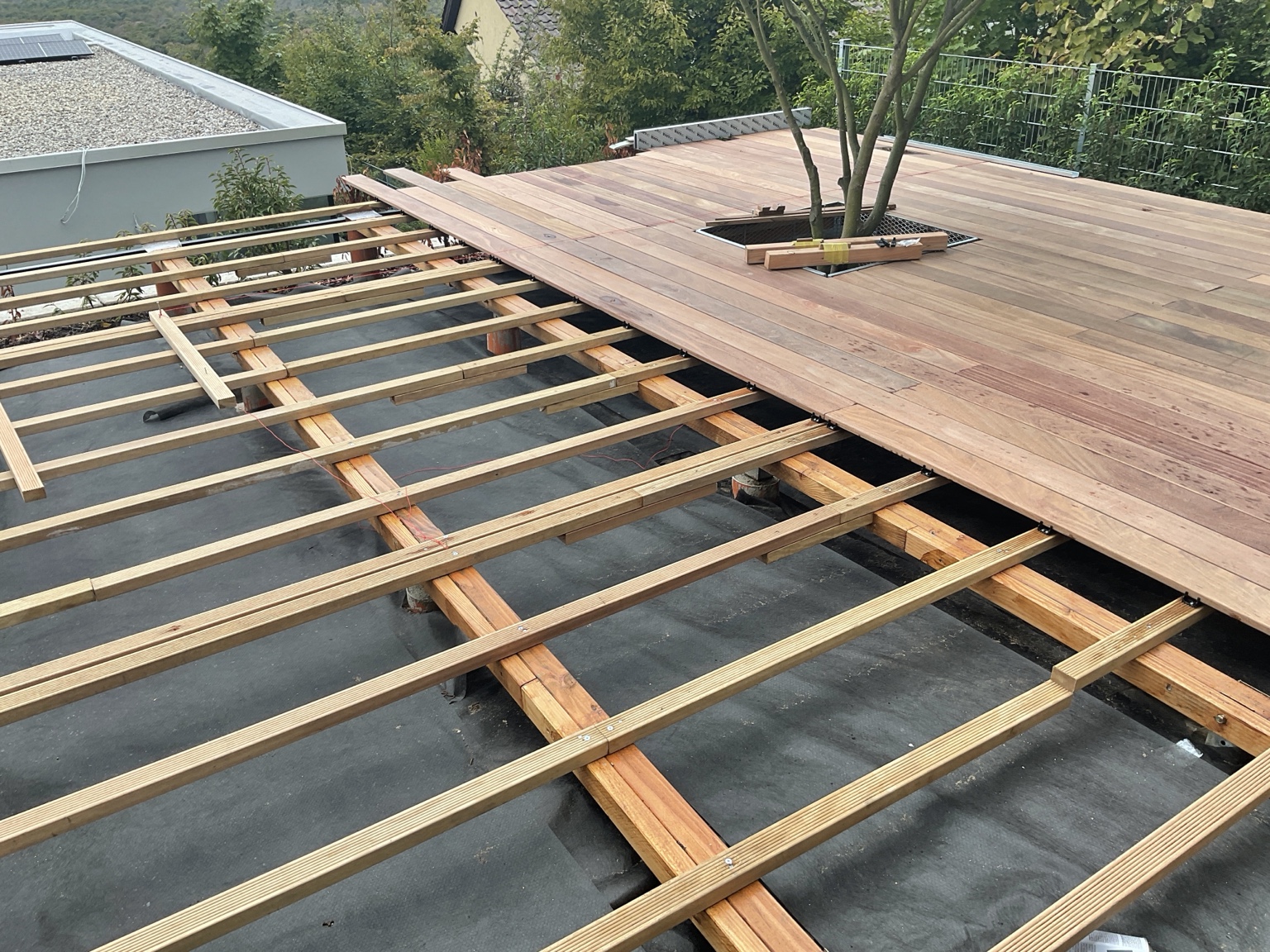 Unterkonstruktion und beginnende Verlegung des Terrassenbelags
